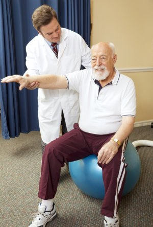 doctor helping senior patient with physical therapy routine