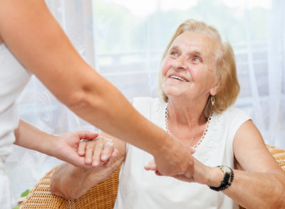 elderly woman holding a hand of a woman